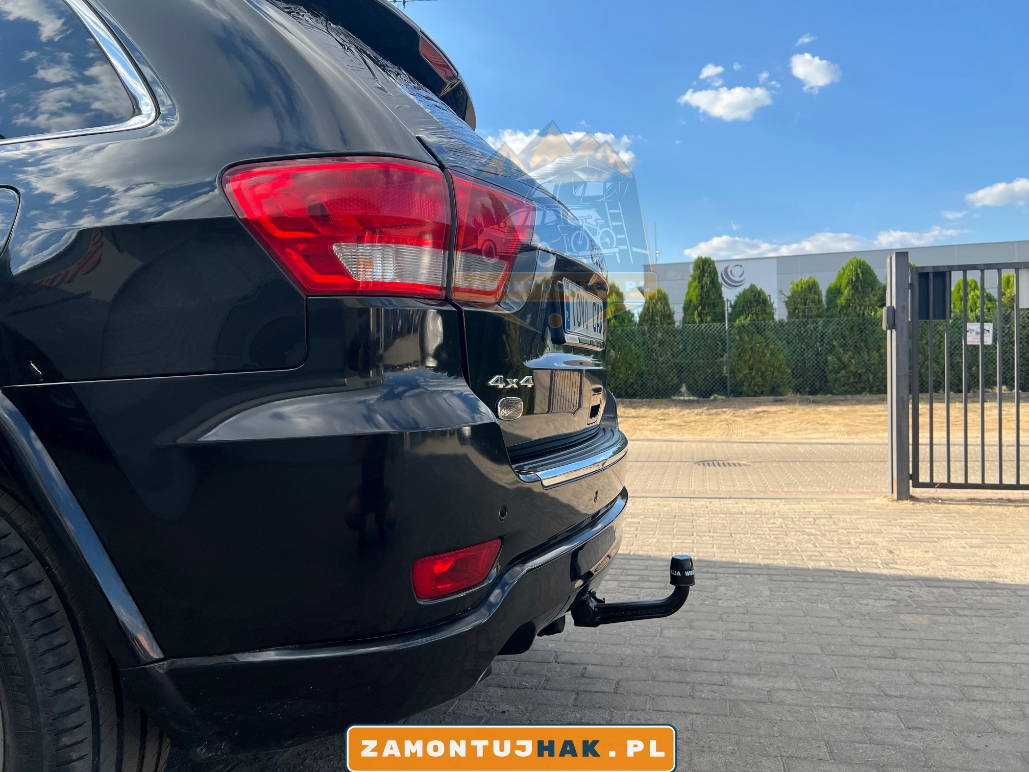 zdjecie od boku ile odstaje hak holowniczy w jeep grand cherokee samochód na tle warsztatu montujacego haki holownicze w poznaniu 